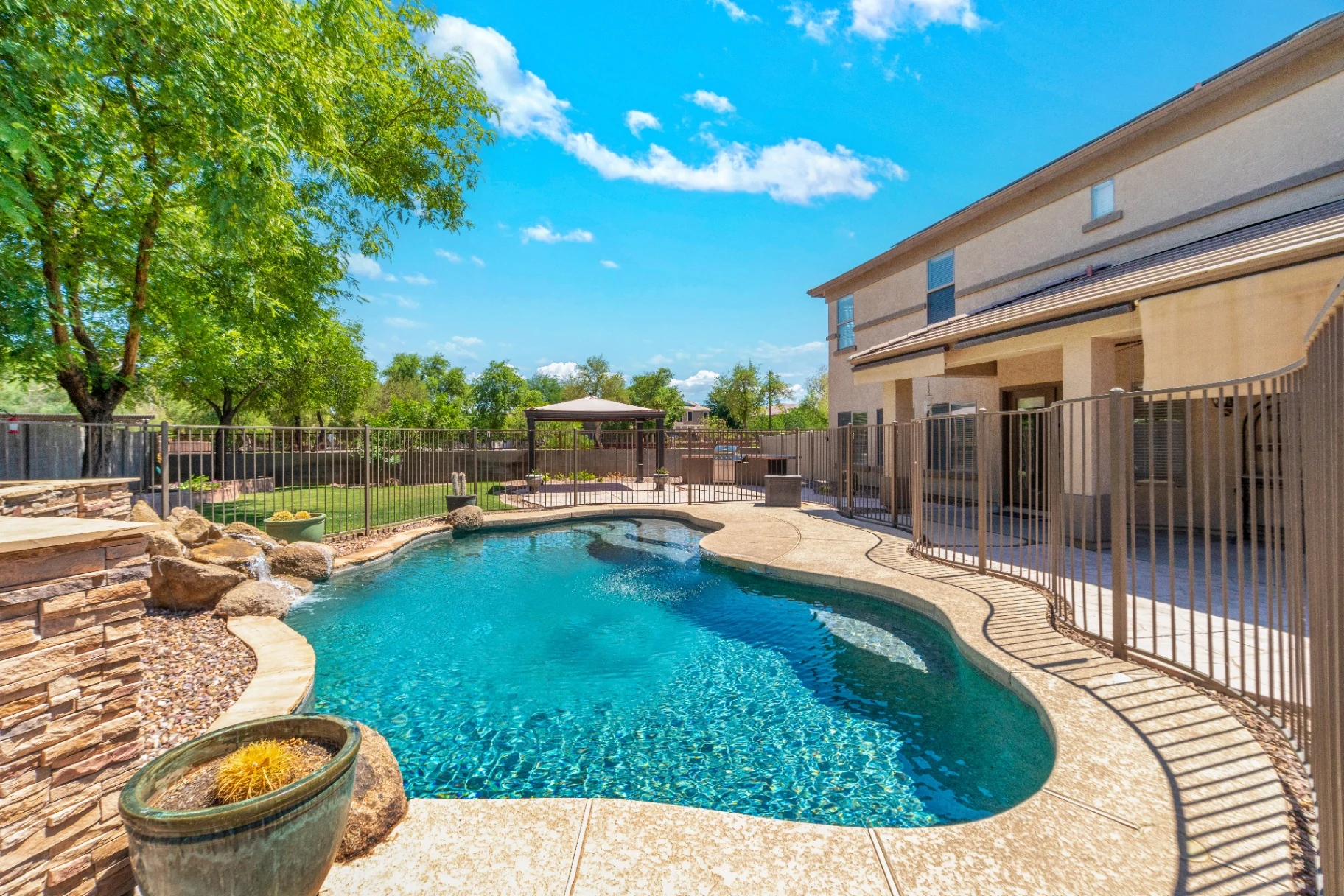 Backyard pool with stone waterfall and freshly resurfaced kool decking in Sun City, AZ